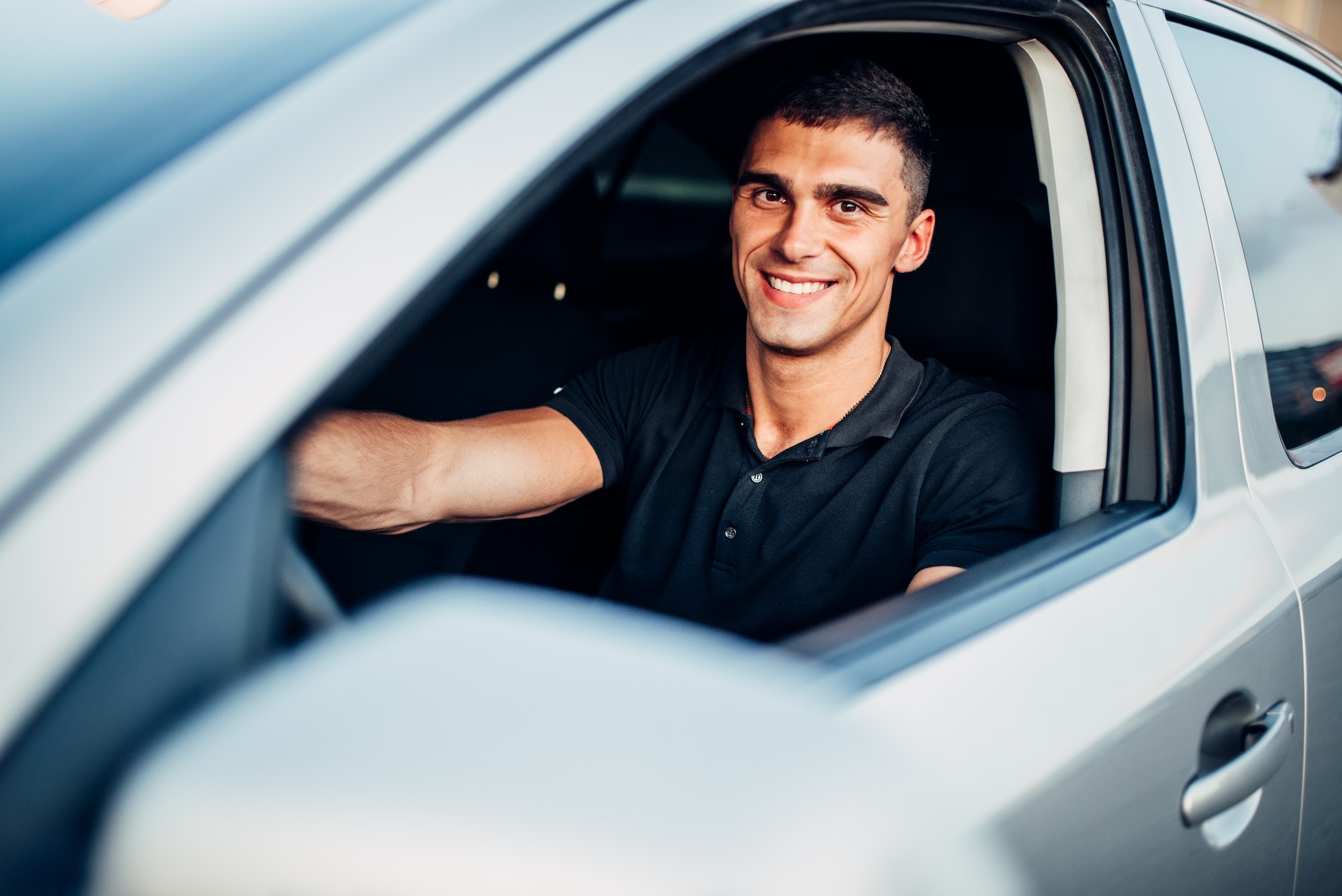 Happy male driver in car, advertising concept
